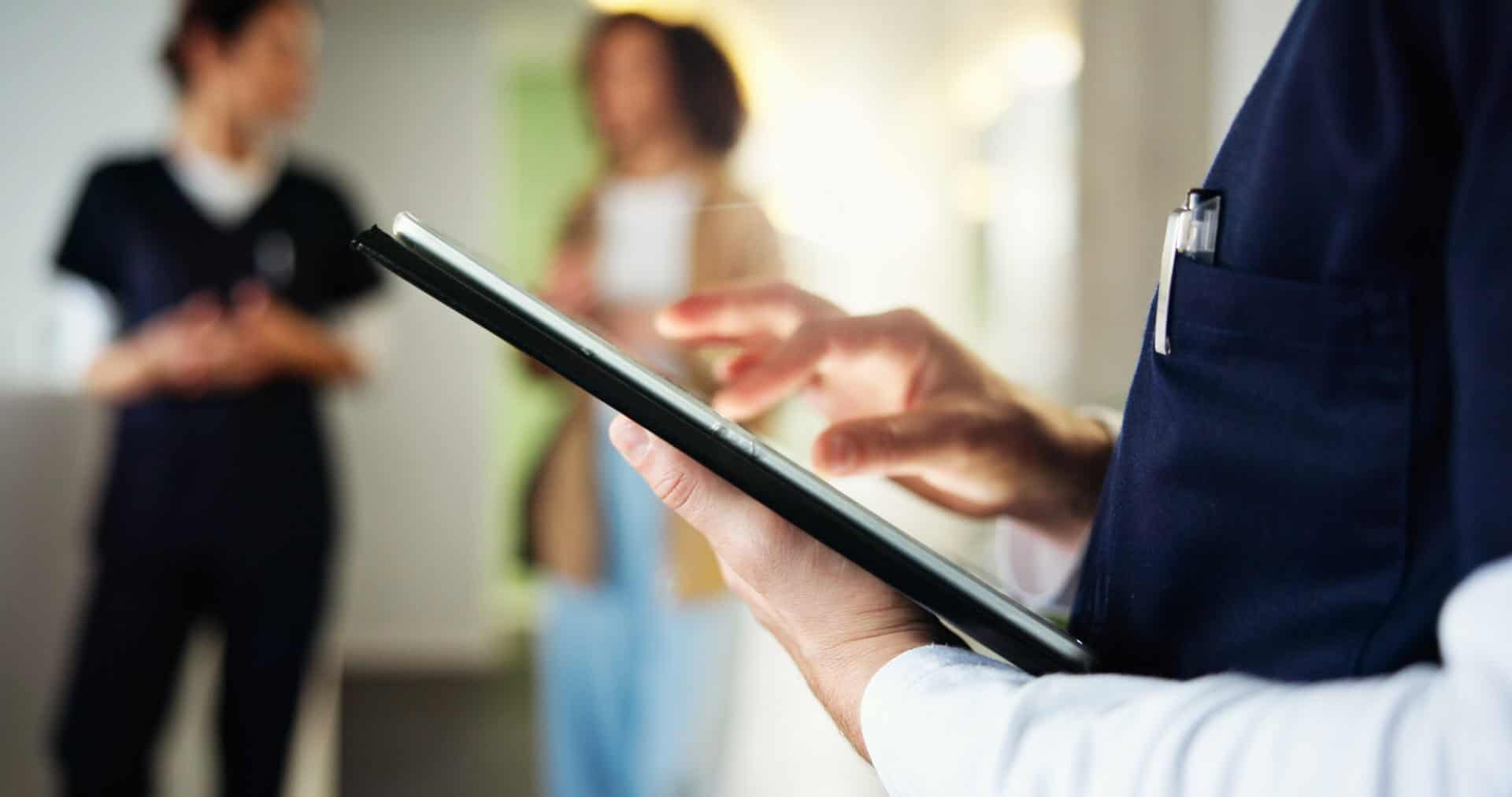Person nutzt Tablet für Dokumentenmanagement im medizinischen Umfeld.