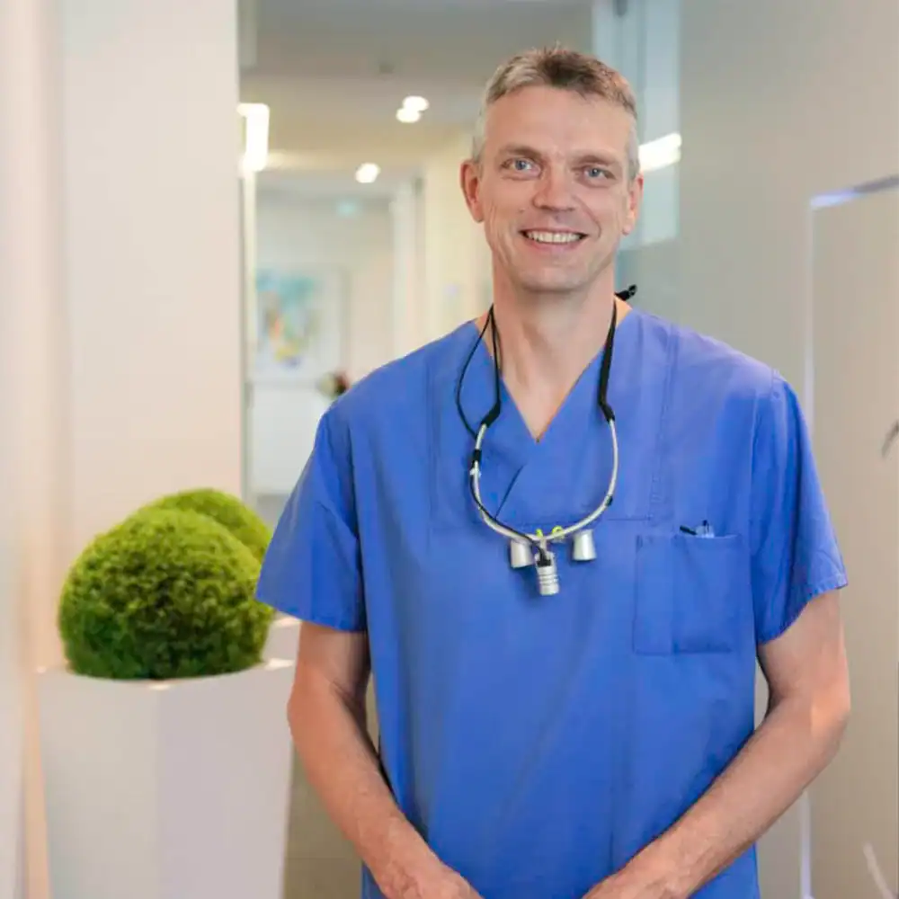 Lächelnder Arzt in blauer Uniform im Krankenhaus.