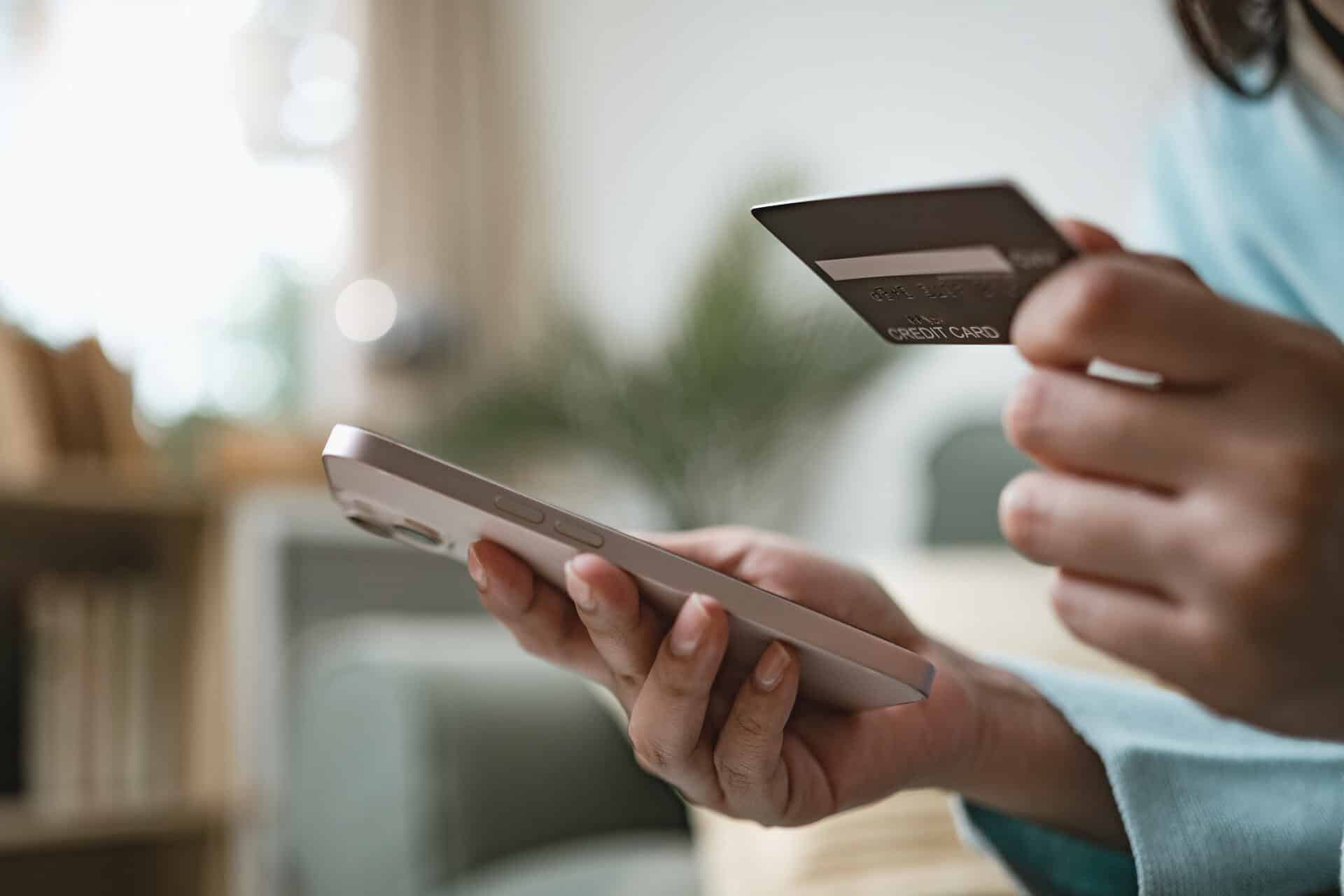 Person bezahlt mit Kreditkarte und Smartphone für DokFee-Service.